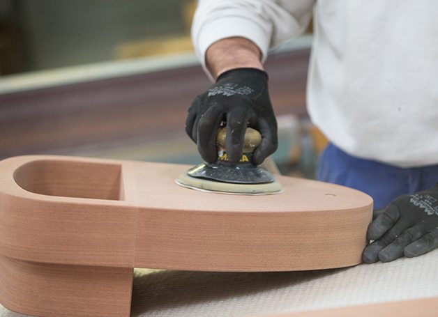person polishing oval wood
