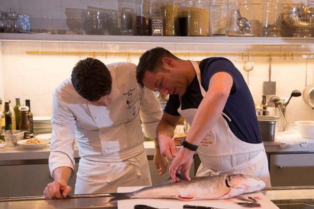 man slicing fish inside kitchen