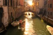 man riding a boat on Venice canal