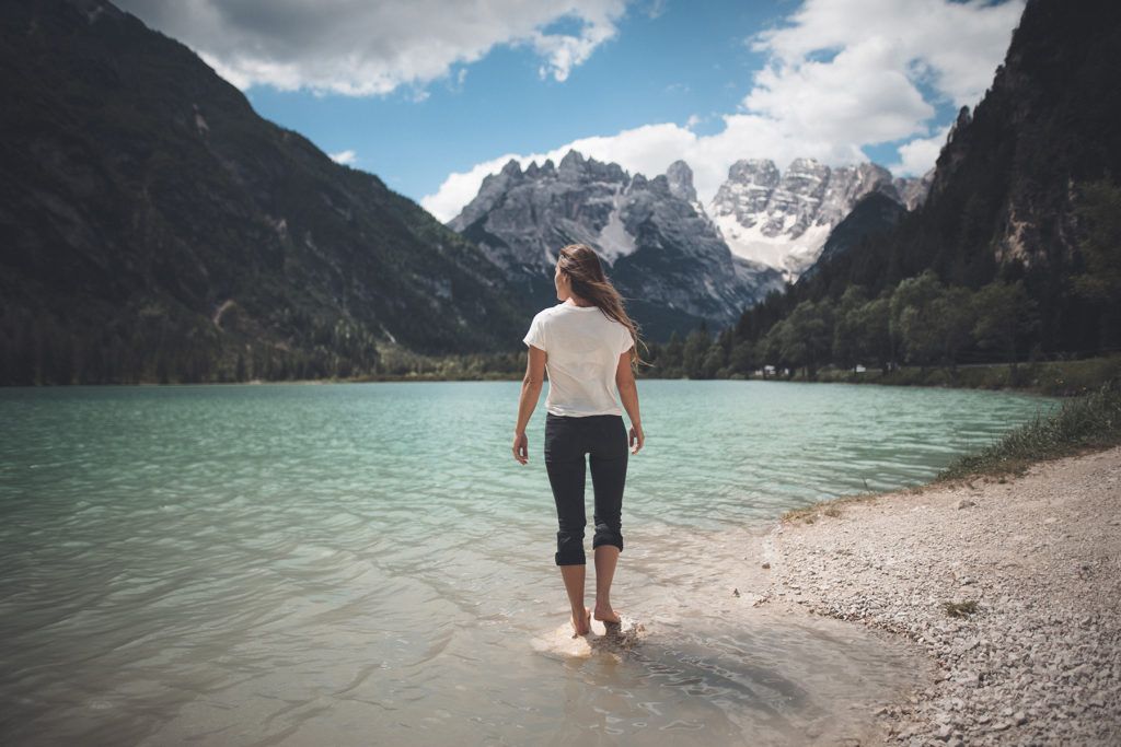woman walking beside the shore during day